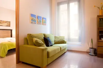 a yellow couch in a living room with a mirror at BCNGOTIC 13 in Barcelona