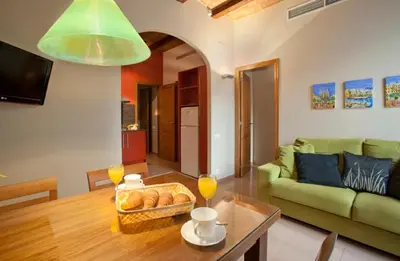 a living room with a green couch and a table at BCNGOTIC 13 in Barcelona