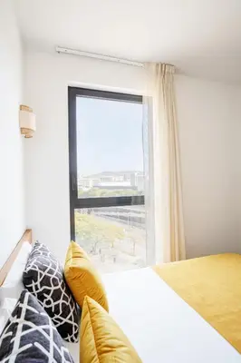 a bedroom with a bed and a large window at Ona Living Barcelona in Hospitalet de Llobregat