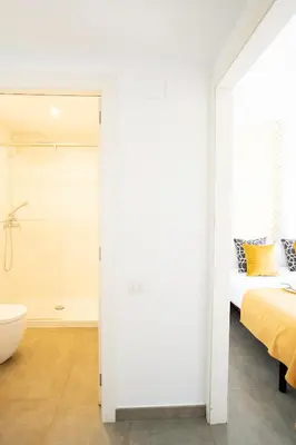 a white bathroom with a bed and a bath tub at Ona Living Barcelona in Hospitalet de Llobregat