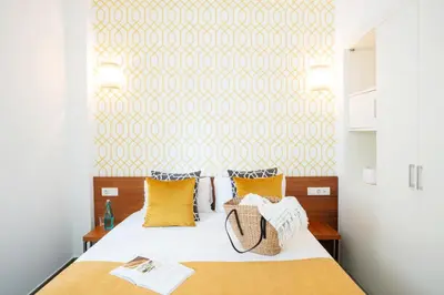a bedroom with a bed with yellow pillows at Ona Living Barcelona in Hospitalet de Llobregat