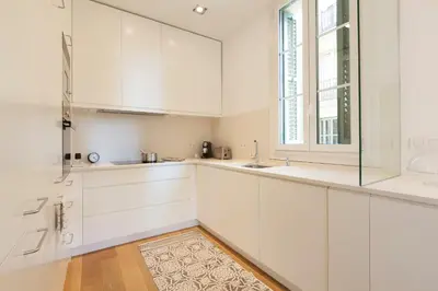 a kitchen with white cabinets and a window at Click&Flat Luxury Sant Joan in Barcelona
