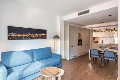 a living room with a blue couch and a table at Aspasios Catedral Apartments in Barcelona