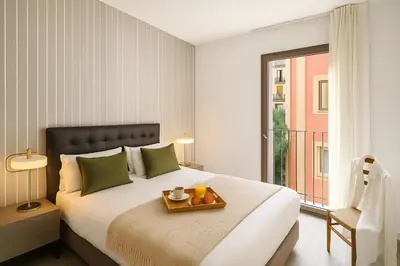a bedroom with a bed with a tray of fruit on it at Aspasios Catedral Apartments in Barcelona