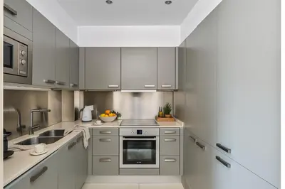 a kitchen with stainless steel appliances and gray cabinets at Aspasios Catedral Apartments in Barcelona