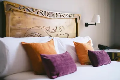 a bed with purple and orange pillows and a wooden headboard at Circa 1905 in Barcelona