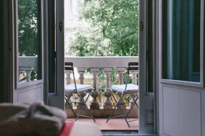 an open door to a balcony with two chairs at Circa 1905 in Barcelona