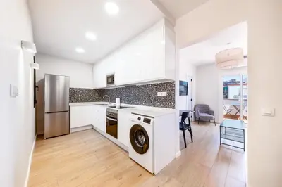 a kitchen with white cabinets and a dishwasher at AinB Barcelona Sants Apartments in Barcelona