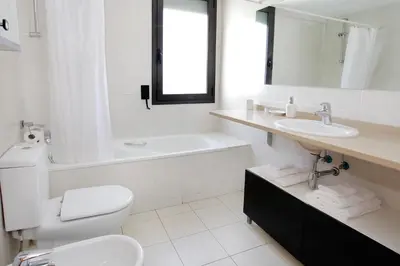 a white bathroom with a sink and a tub and a toilet at 1217 - POOL AND BEACH NICE APARTMENT II in Barcelona
