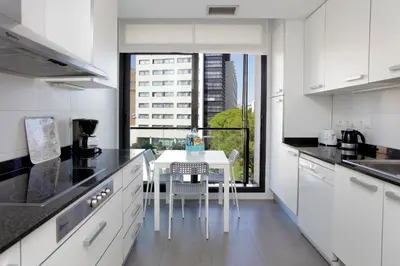 a white kitchen with a table and a view of a building at 1214 - TWO BEDROOMS CIUTADELLA APARTMENT in Barcelona
