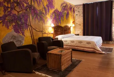 a bedroom with a bed and a table and chairs at Hotel Moli De La Torre in Bigues i Riells
