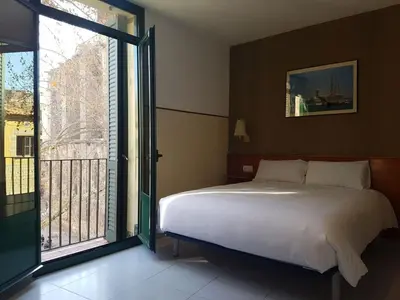 a bedroom with a bed and a large window at El Jardi in Barcelona