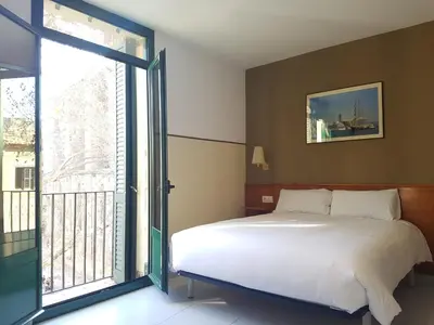 a bedroom with a bed and a sliding glass door at El Jardi in Barcelona