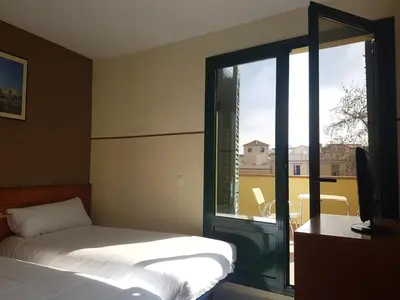 a bedroom with a bed and a sliding glass door at El Jardi in Barcelona