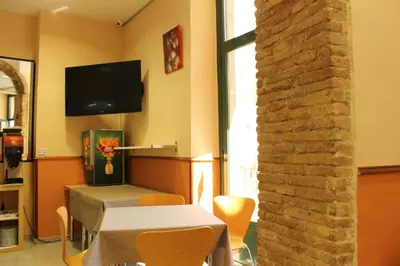 a dining room with a table and a tv on the wall at El Jardi in Barcelona