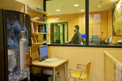a man standing in front of a desk with a computer at El Jardi in Barcelona