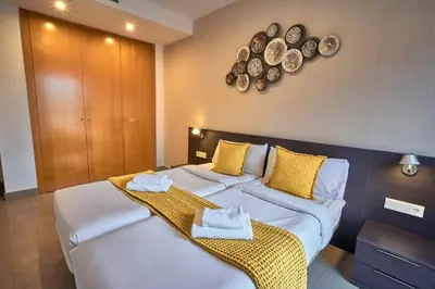a bedroom with two beds and plates on the wall at Bonavista Apartments - Virreina in Barcelona