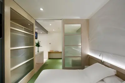 a bedroom with a bed and a bathroom with a mirror at Ako Suite Hotel in Barcelona