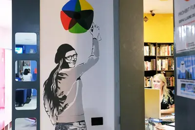 a painting of a woman holding a ball on a wall at Alternative Creative Youth Hostel Barcelona in Barcelona