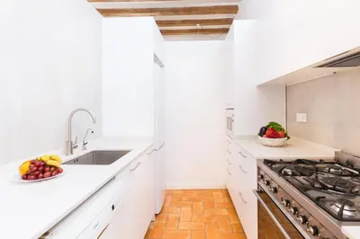 a kitchen with white counters and a sink and a stove at Montaber Apartment - Trafalgar in Barcelona