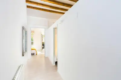 a hallway of a house with white walls and wooden ceilings at Montaber Apartment - Trafalgar in Barcelona