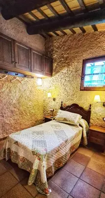 a bedroom with a bed in a stone wall at Masia Can Felip B&B in Llinars del Vallès
