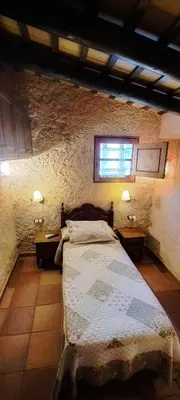 a bedroom with a bed and two tables and a window at Masia Can Felip B&B in Llinars del Vallès