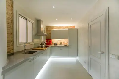 a kitchen with white cabinets and a window at Montaber Apartment - Bailén in Barcelona