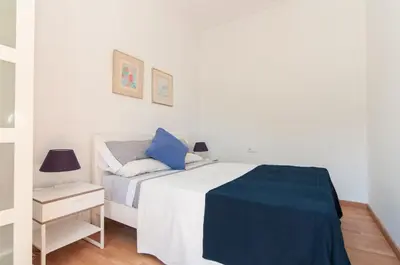 a bedroom with a bed with a blue blanket on it at Montaber Apartment - Sant Antoni in Barcelona