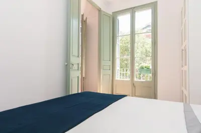 a bedroom with a white bed and a window at Montaber Apartment - Sant Antoni in Barcelona