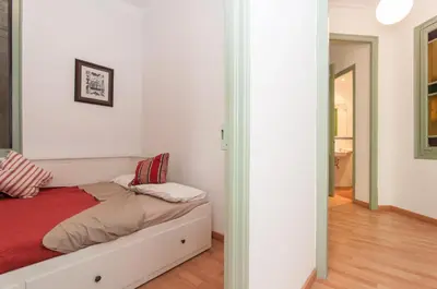 a white bedroom with a bed with a red blanket at Montaber Apartment - Sant Antoni in Barcelona