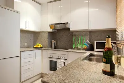 a kitchen with white cabinets and a bottle of wine at Sagrada Familia Apartment 265 in Barcelona