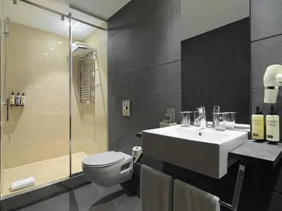 a bathroom with a tub and a sink and a shower at H10 Casanova in Barcelona