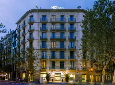 a patio with white tables and chairs and umbrellas at H10 Casanova in Barcelona