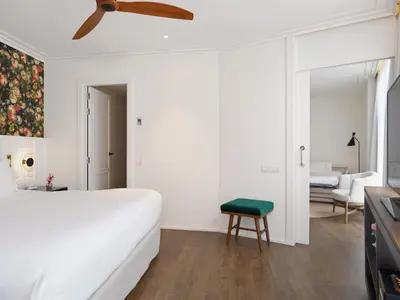 a bedroom with a white bed and a green stool at H10 Casanova in Barcelona