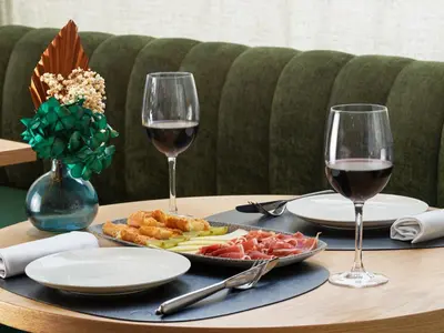 a table with a plate of food and two glasses of wine at H10 Casanova in Barcelona