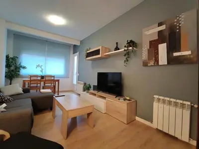 a living room with a couch and a flat screen tv at LG DownTown Sabadell Apartment in Sabadell