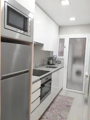 a kitchen with a stainless steel refrigerator and a microwave at Family Deluxe Apartment Beach in Castelldefels