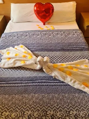 a bed with a towel with a heart on it at Hostal Rio De Castro in Barcelona