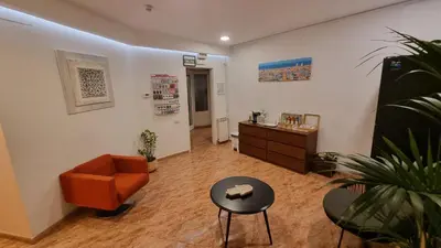 a living room with an orange chair and a table at Hostal Rio De Castro in Barcelona