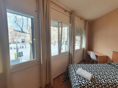 a bedroom with a bed and a large window at Hostal Rio De Castro in Barcelona