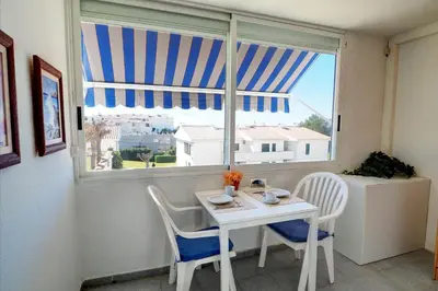 a table and chairs in a room with a window at The Moon Studio by Hello Homes Sitges in Sitges