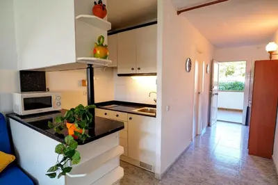 a kitchen with white cabinets and a black counter top at The Moon Studio by Hello Homes Sitges in Sitges