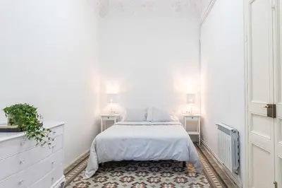 a white bedroom with a bed and a rug at B-Garden BCN in Barcelona