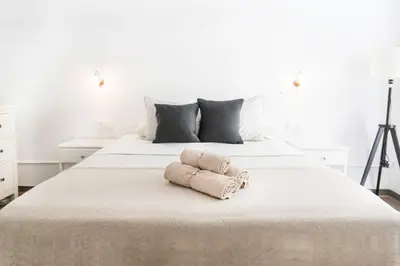 a white bed with two towels on top of it at B-Garden BCN in Barcelona