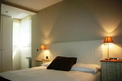 a bedroom with a bed with two lamps on it at Montseny Suites & Apartments in Montseny