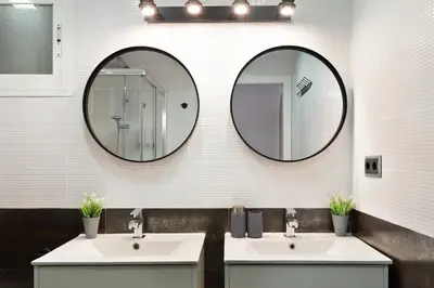 two sinks in a bathroom with two mirrors at KeyFamily Paradise in Barcelona
