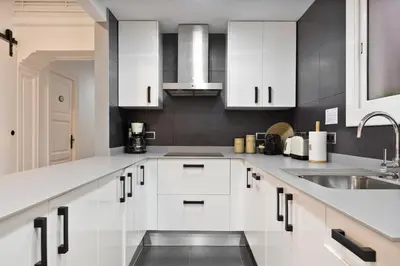 a kitchen with white cabinets and a sink at KeyFamily Paradise in Barcelona