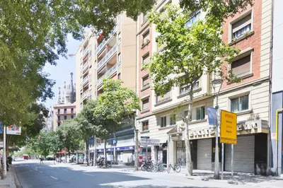 a city street with buildings and a yellow street sign at KeyFamily Paradise in Barcelona