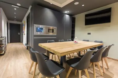 a conference room with a wooden table and chairs at Airhostel Barcelona Airport 24h in El Prat de Llobregat